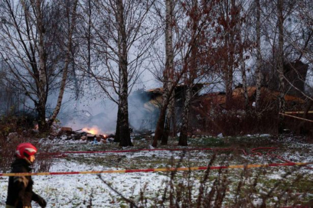 Photo of a Lithuanian rescuer walks past the wreckage in Vilnius today